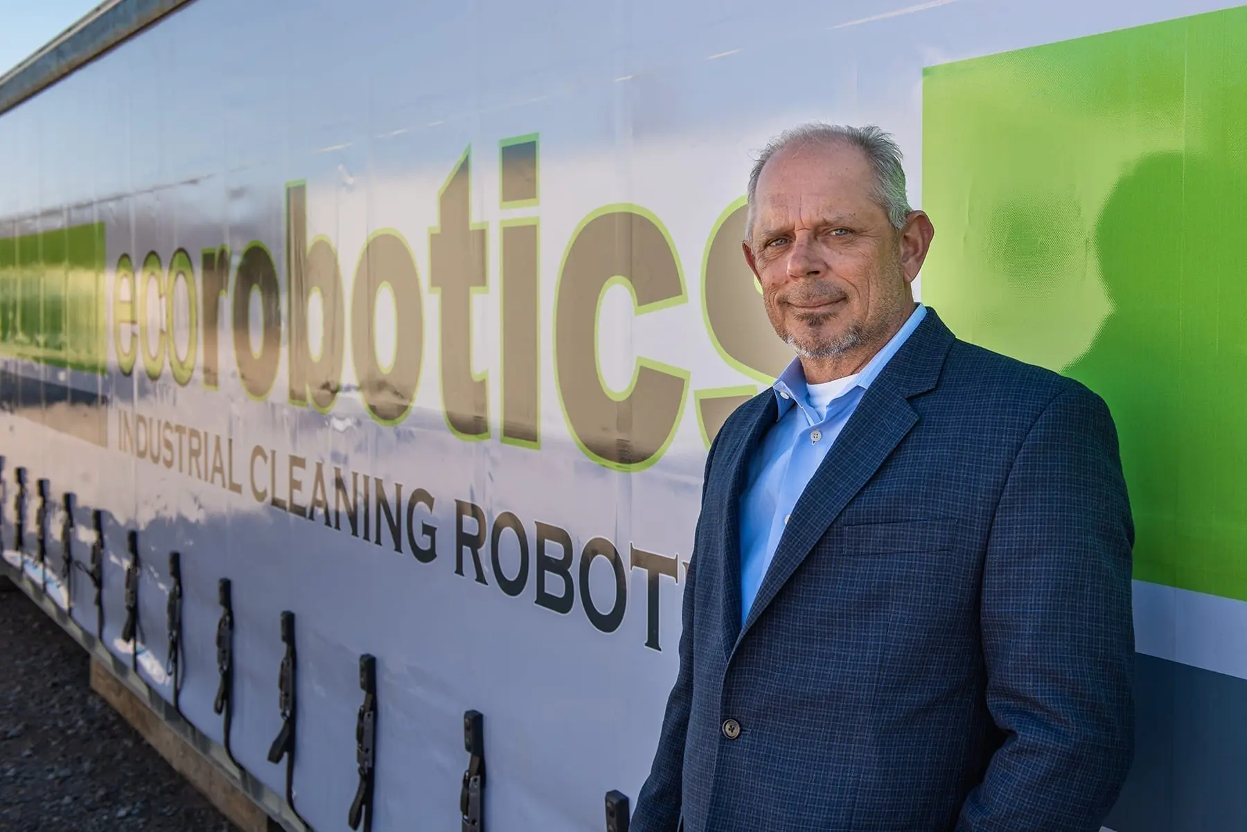 Kenny standing in front of the ecorobotics logo