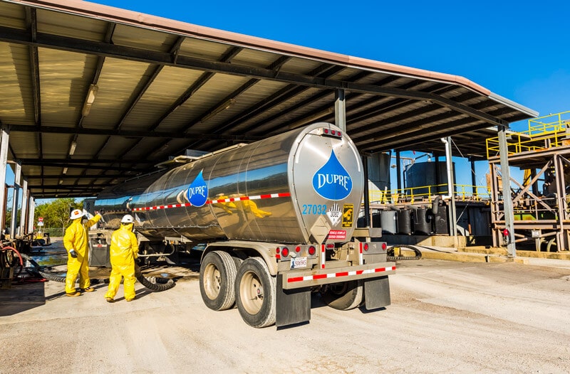 Permian Facility Waste Transfer men working with waste transportation truck